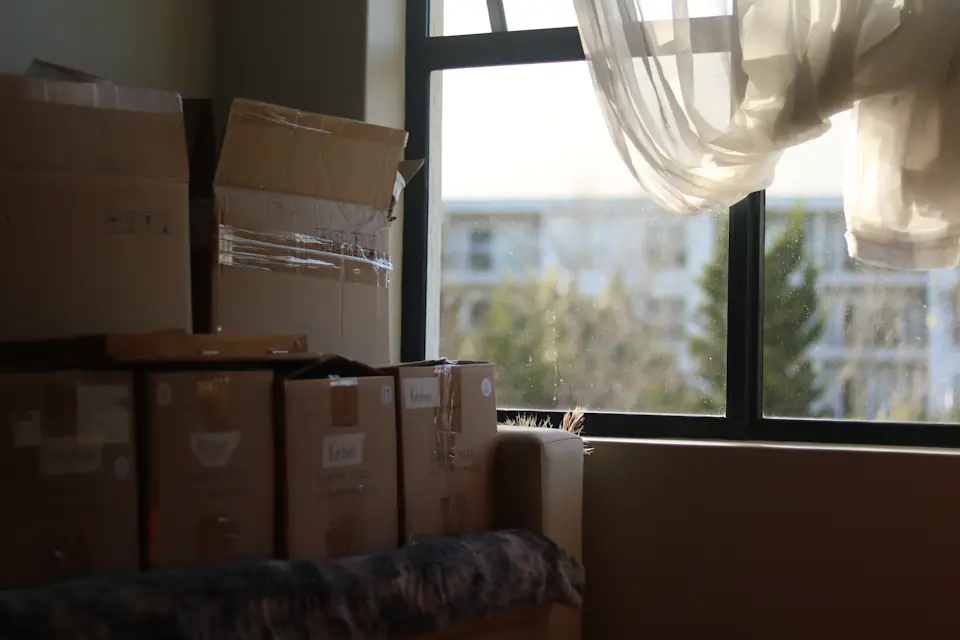 Packed boxes in a Newcastle apartment Packed moving boxes stacked beside a large window in an empty flat
