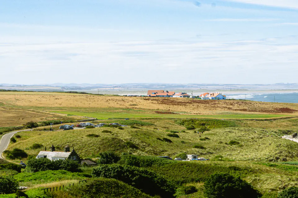 Leaving the North East coast on a long distance move Northumberland coastline with green fields, a sandy beach and a distant town