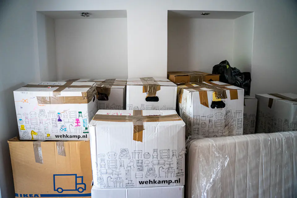 Labelled boxes packed for a Newcastle move Labelled cardboard boxes stacked on a wooden table in a home